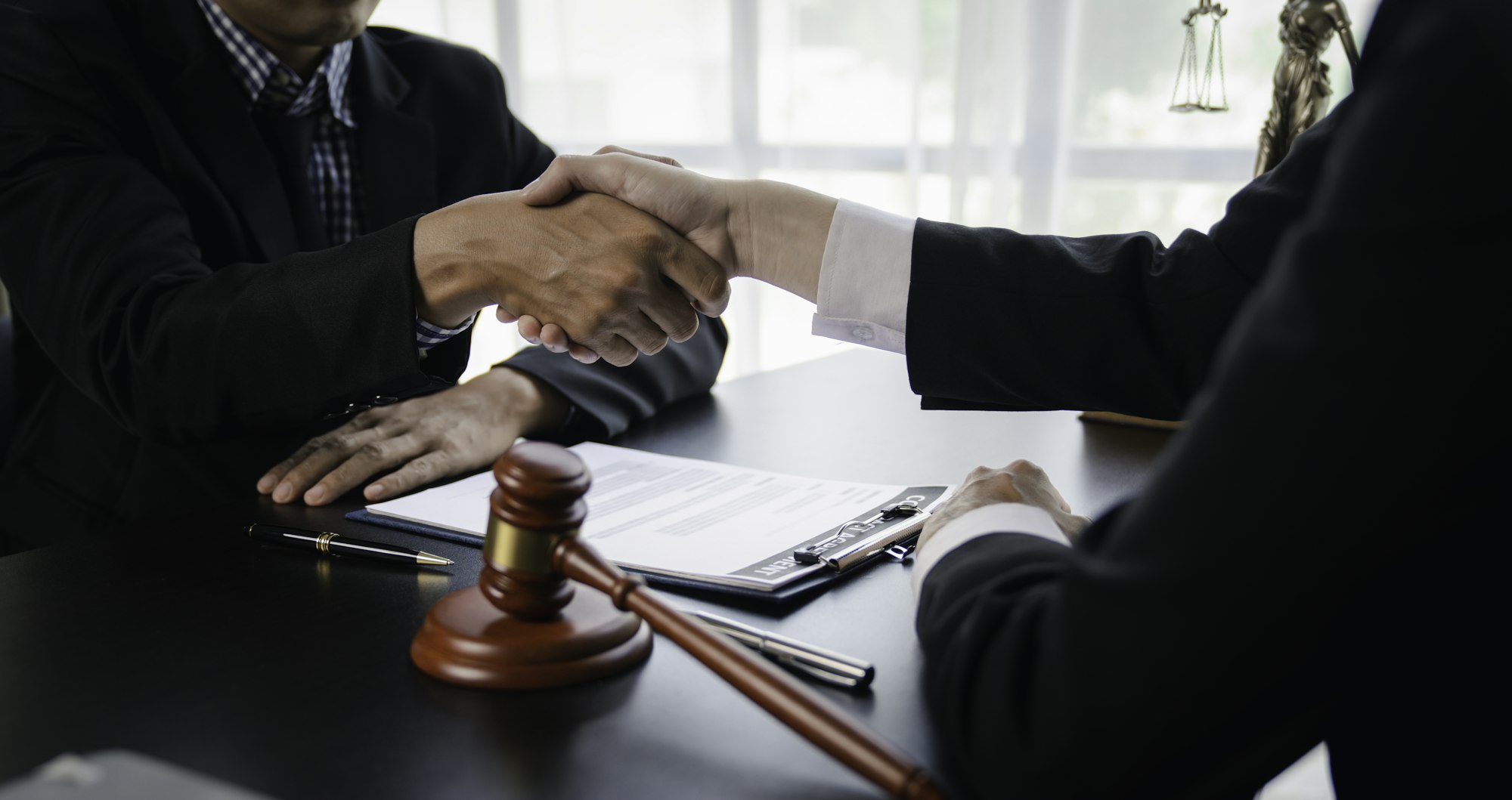 Lawyers shake hands with business people to seal a deal with partner lawyers. or a lawyer discussing